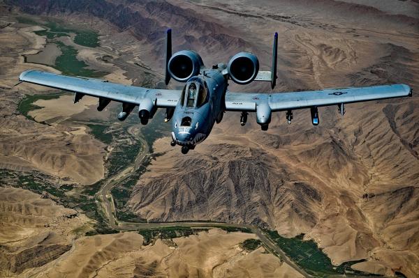 Gray Jet Fighter Flying Above Brown Mountain