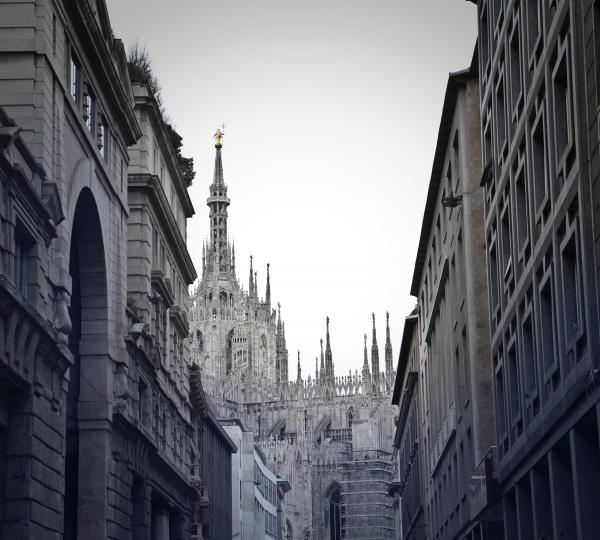 Grayscale Photo of Alley With Tower Background