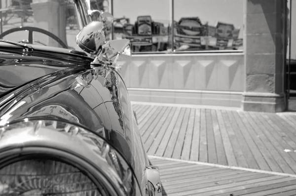Grayscale Photo of Car Near Glass Panel