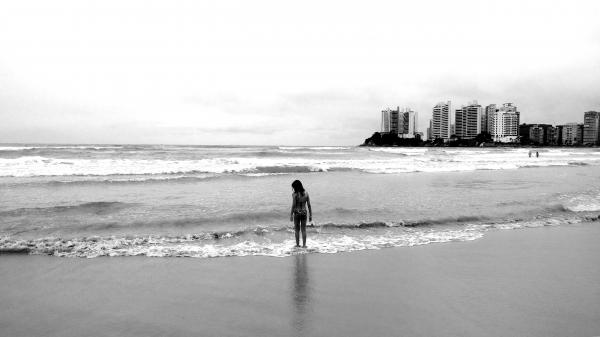 Grayscale Photo of Female Standing Seashore