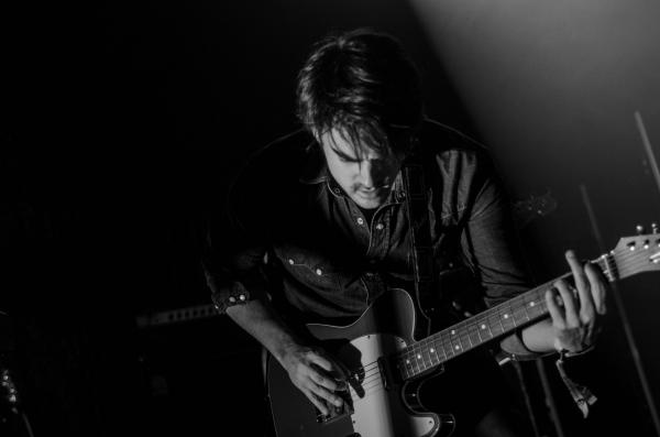 Grayscale Photo of Man Playing Electric Guitar
