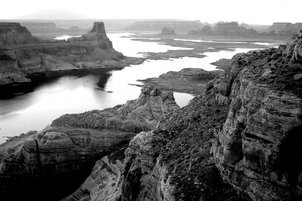 Grayscale Photography of High Rise Rock Near Body of Water