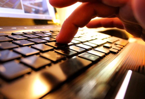 Hands typing on laptop keyboard