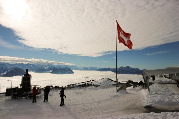 High-saturated Silhouette Photography of Three Person Standing Near Red and White Cross Printed Flag