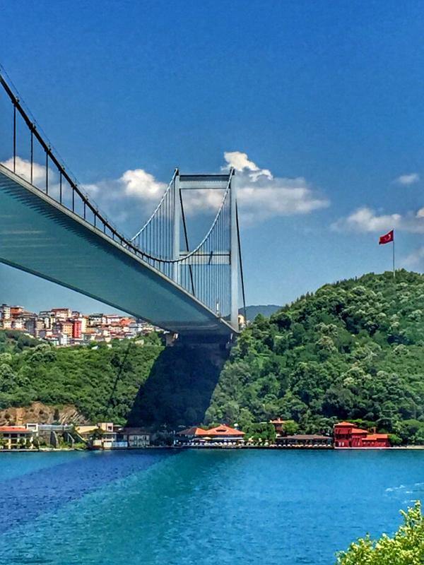 Houses Under Gray Concrete Long Bridge Under Blue Sky