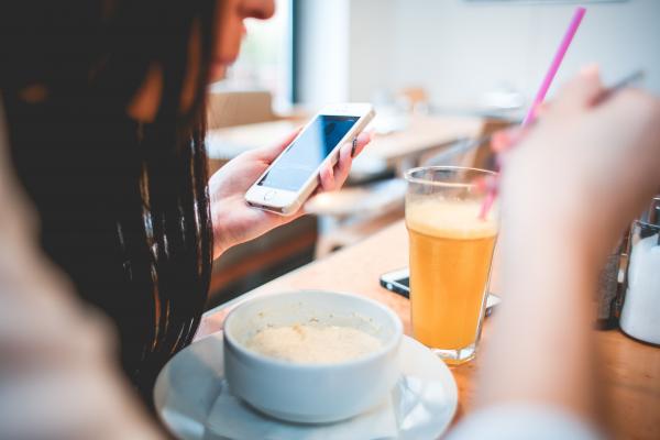Human Holding Iphone Infront on White Round Bowl