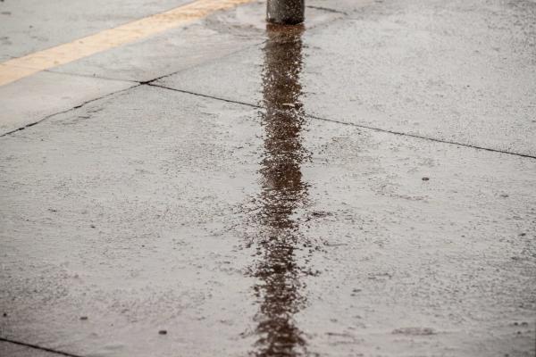 Lamp post reflection on rainy ground