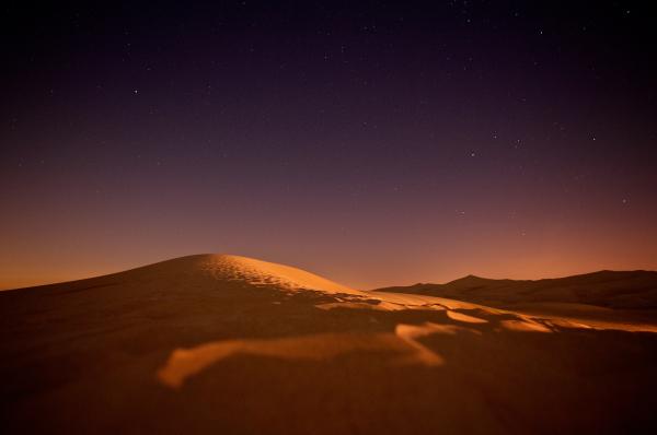Landscape of Sand Dunes at Dusk with Stars in Sky