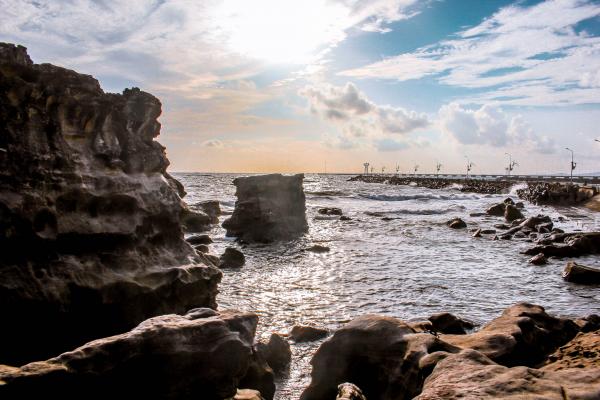 Landscape Photography of Rocks Surrounded by Body of Water