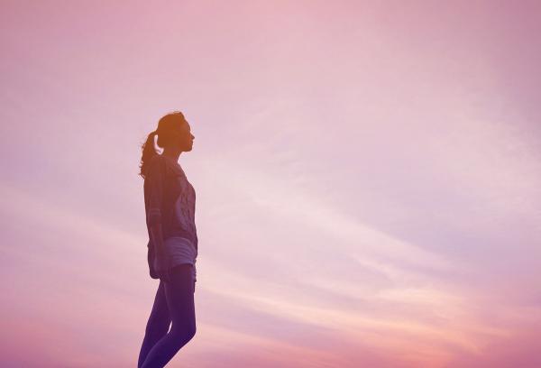 Lone Young Girl at Sunset Looking at the Far Horizon