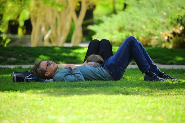Man and Woman Lying on Green Field