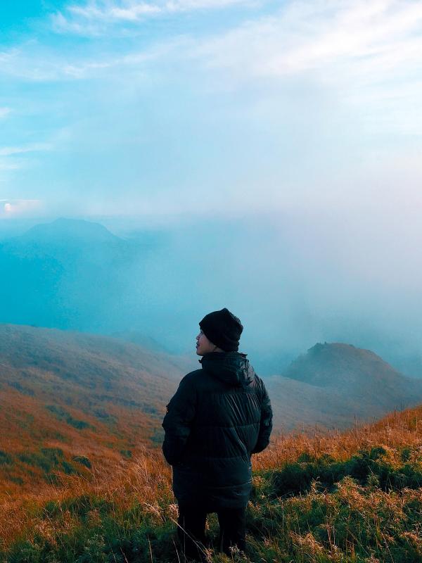 Man in Black Jacket Standing on Mountain With Fog