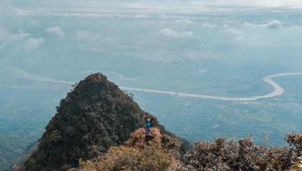 Man in Blue on Top of the Mountain With Areal View