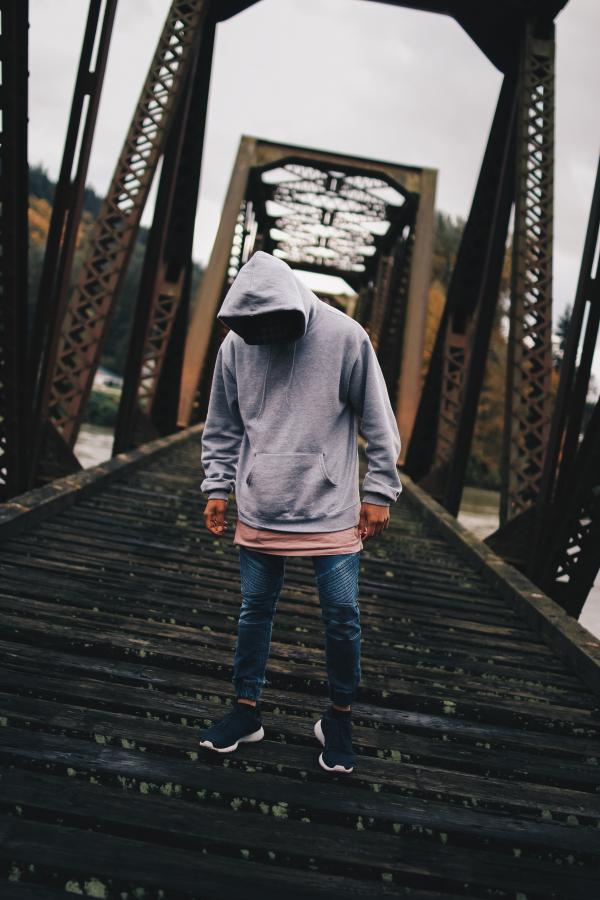 Man in Gray Pull-over Hoodie Standing on Train Rail