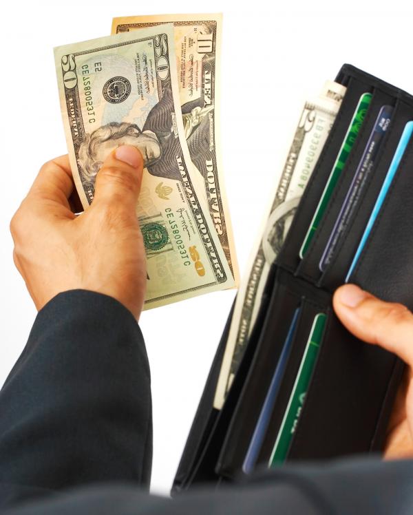 Man Paying A Bill In Dollars Cash