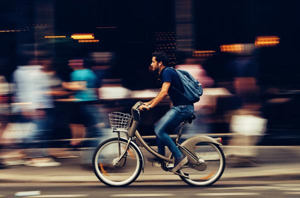 Man Riding Bicycle on City Street