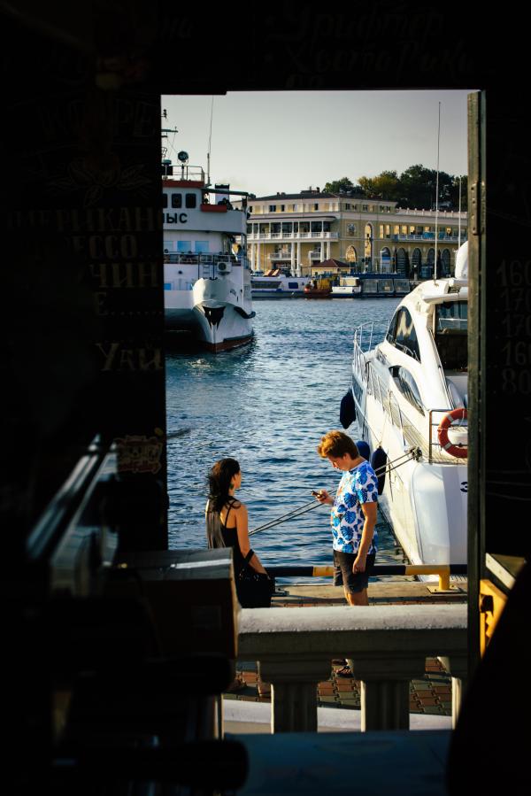 Man Standing Beside Woman Near White Yacht
