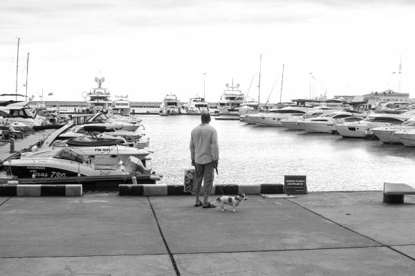 Man Standing On A Concrete Dock Near Body Of Water