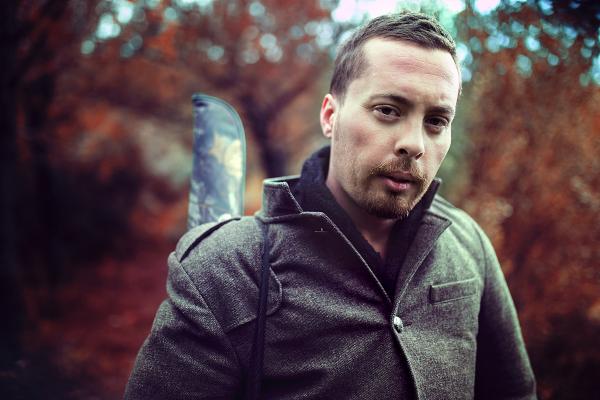 Man Wearing Gray Jacket in Front of Trees