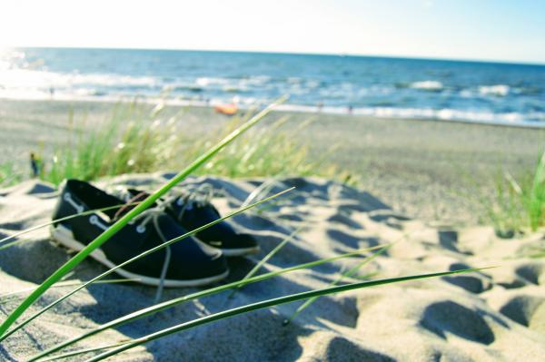 Moccasin shoes lie on the sand dune