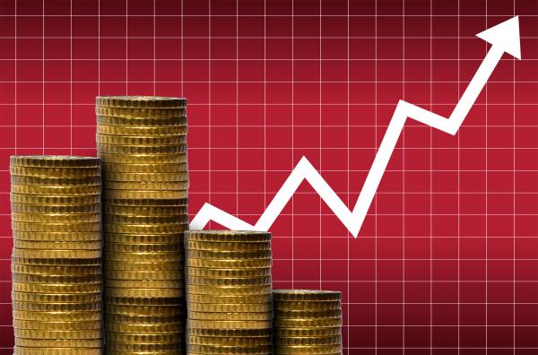 Money in a pile of coins with financial graph