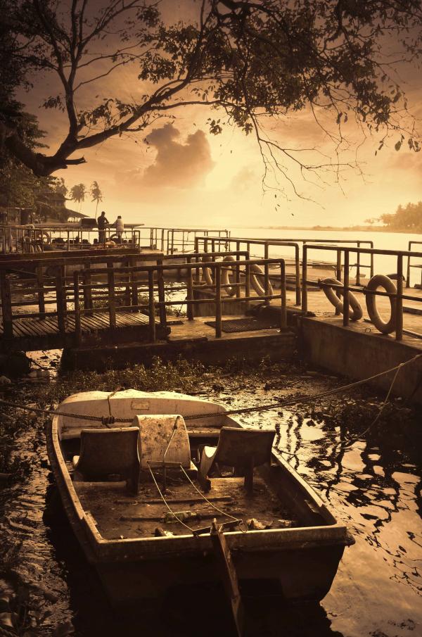 Old broken and tied up boat in River
