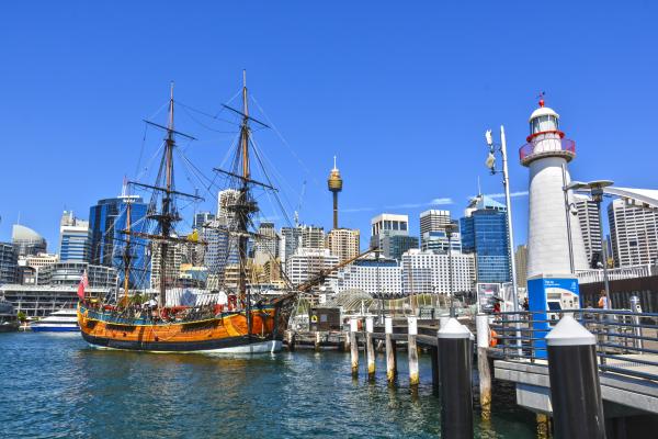 Orange Galleon Ship on Body of Water Beside City Buildings