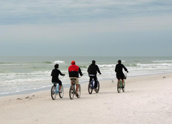People riding bikes on the beach