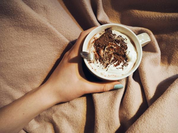 Person Holding Cup With Coffee Latte With Spoon Inside