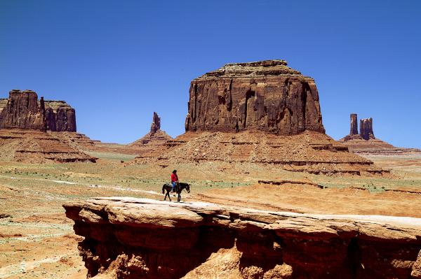 Person on Black Horse on Rock Cliff