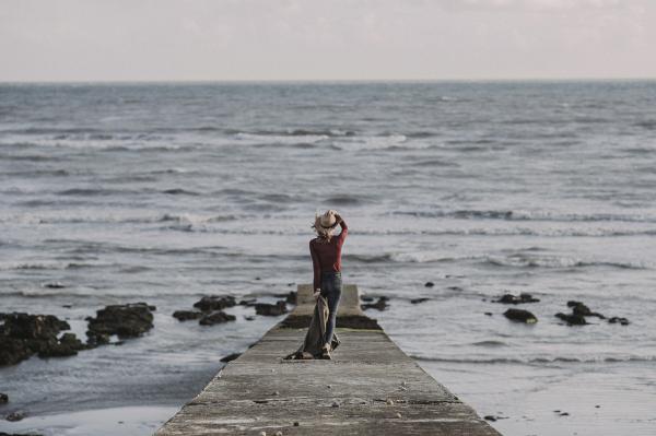 Person Standing on Dock Holding Textile