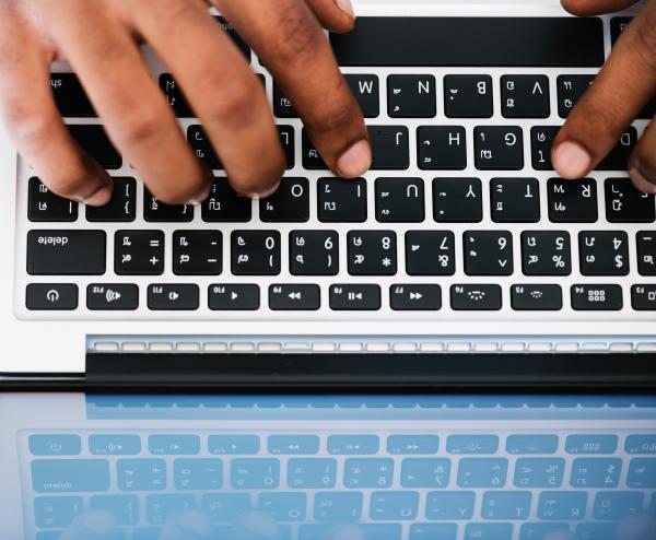 Person Typing on White and Black Laptop Computer