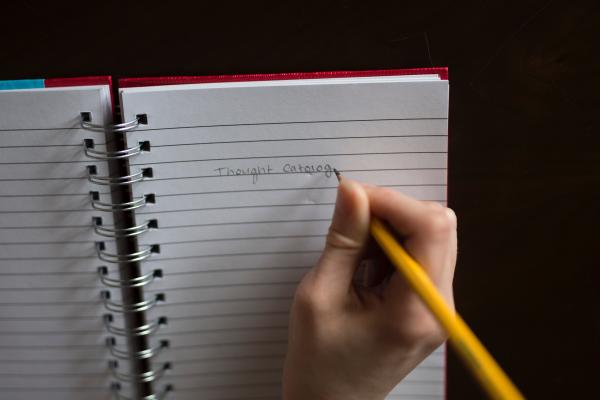 Person Writing on White Lined Paper