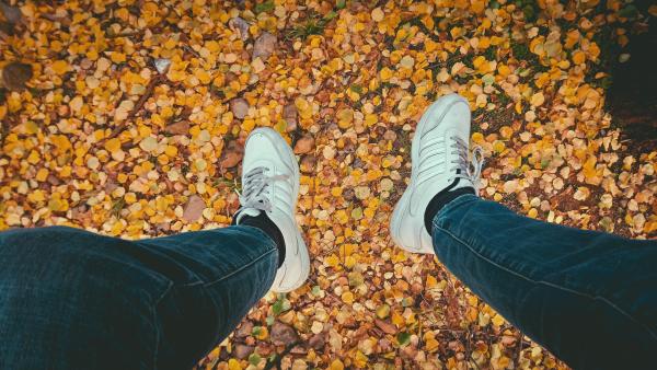 Person's Wearing Blue Jeans and Pair of White Sneakers