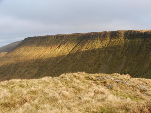 Photo of Gray Grass Field Across Hill
