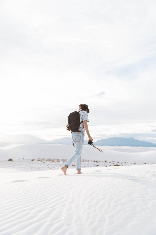 Photo of Person Walking Along Seashore