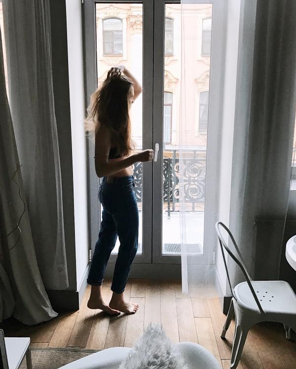 Photo of Woman in Blue Pants Holding Her Hair
