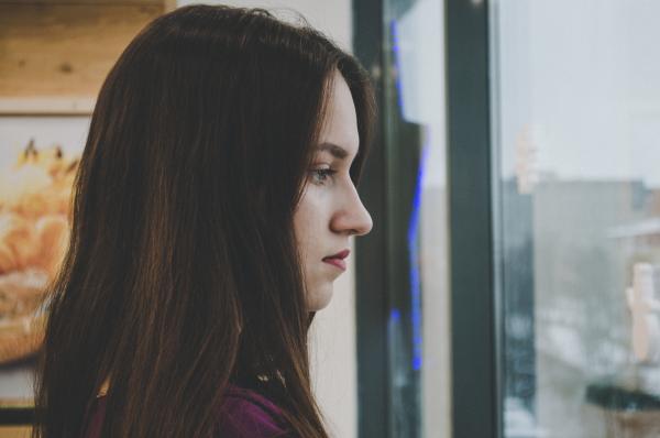 Photography of a Woman Looking Outside the Window
