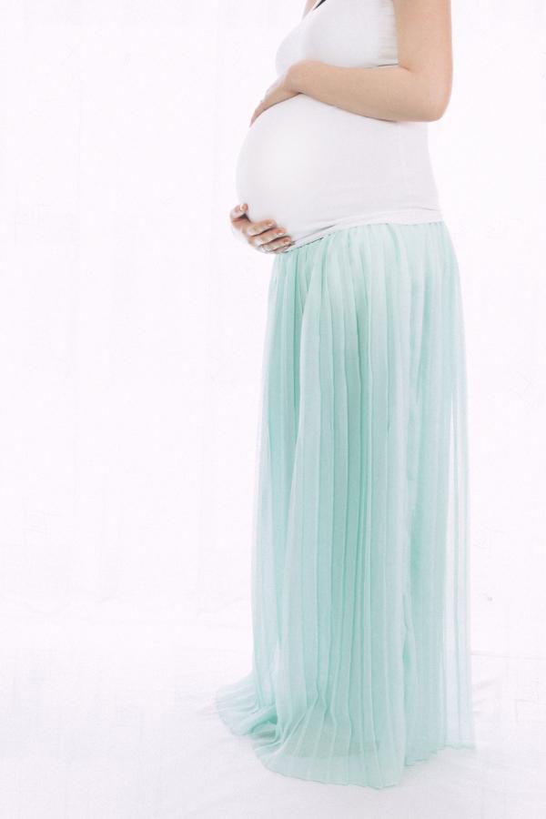 Pregnant Woman Standing in Front of White Wall