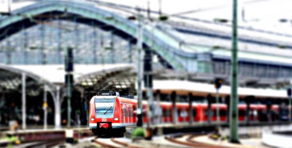 Red Train at a Green Train Station on an Overcast Day