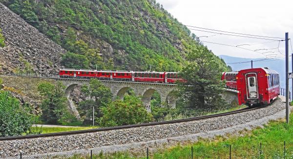 Red Train on Black Steel Train Rail during Day