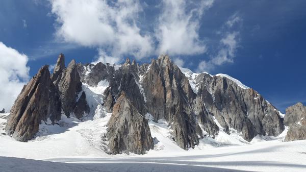 Rock Mountain Covered With Snow Under Blue Sky at Daytime