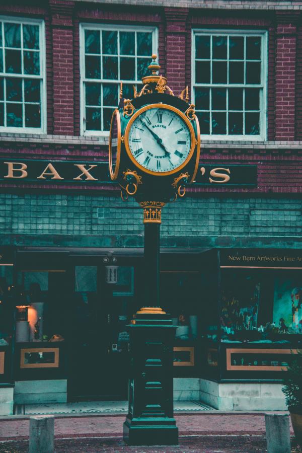 Round Yellow and Black Analog Pedestal Clock Displaying 4:58