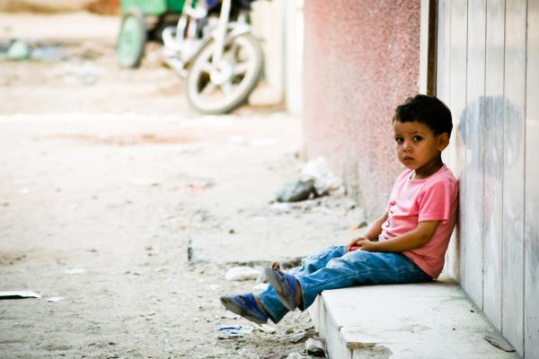 Sad little boy waiting outside