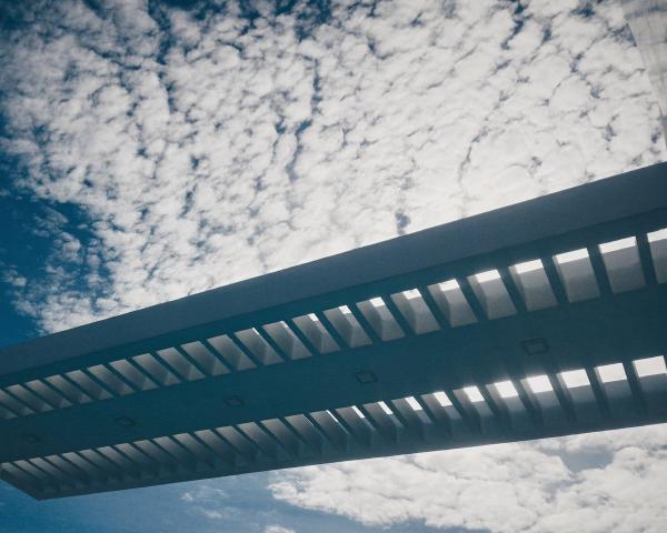 Silhouette of Bridge Under Cloudy Sky