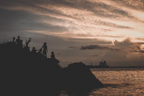 Silhouette of People on Mountain Near Body of Water