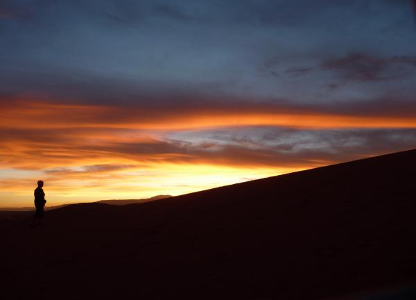 Silhouette of Person Standing Facing the Sunset