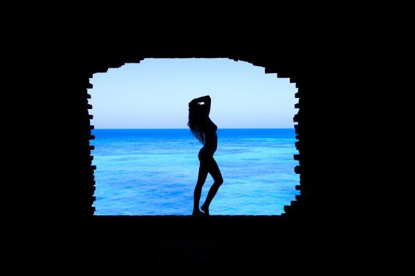Silhouette of Woman Standing Between Walls
