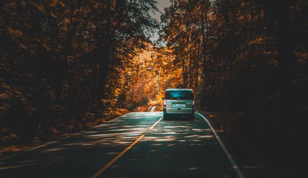 Silver Van Traveling on Highway Lined With Trees during Daytime
