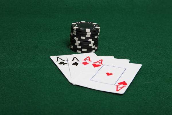 Stack of black poker chips with four ace